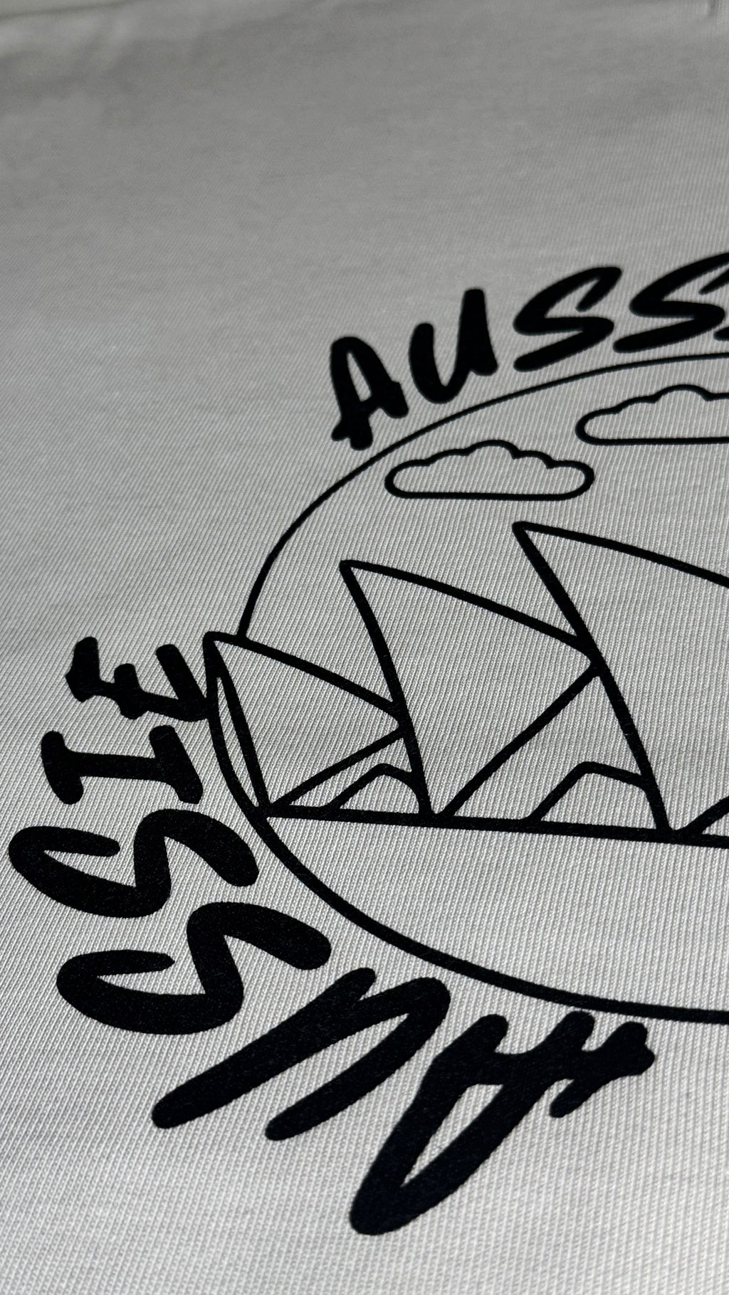Gray fabric with black 'Aussie' text and Sydney Opera House design.
